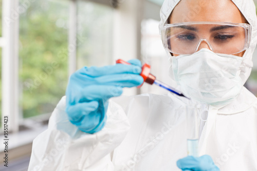 Photo: Protected science student dropping a liquid in a test tube Protected science student dropping a liquid in a test tube