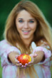 young woman offering red apple