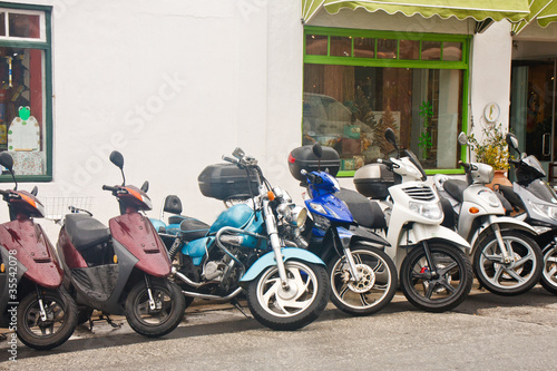 Photo: Line of Mopeds in Front of Shops Line of Mopeds in Front of Shops