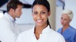 Female doctor smiling with team in background