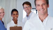 Male medical professional smiling with his confident team