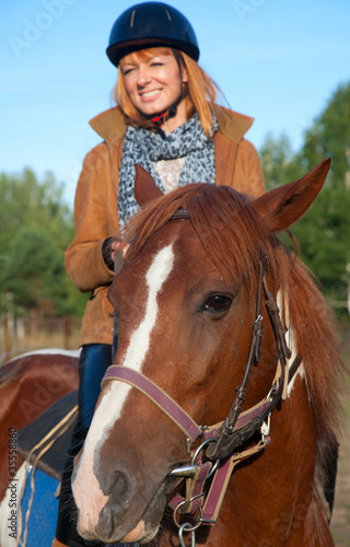 Photo: A woman riding a horse A woman riding a horse