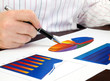 Businesswoman hand with pen on the investment chart. Businesswoman hand with pen on the investment chart.