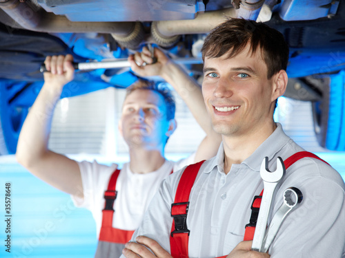 Photo: Motor mechanic is satisfied with his job in a garage Motor mechanic is satisfied with his job in a garage