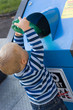 child putting waste in bin