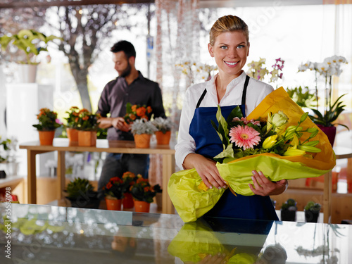 Photo: Young woman and client in flowers shop Young woman and client in flowers shop