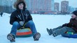 The boys sit on the sled and pushing in the winter