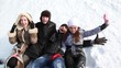 Young people are lying on the snow and laughing.