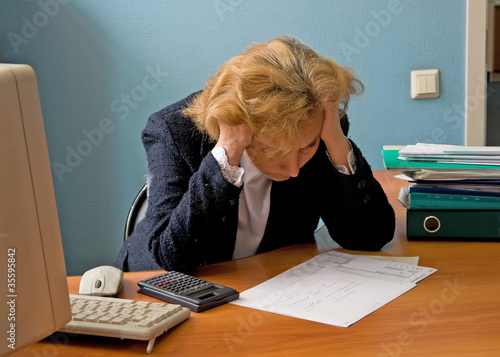 Photo: Office working woman in meditation over the report Office working woman in meditation over the report