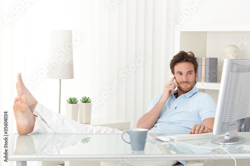 Photo: Cool man with feet up on desk Cool man with feet up on desk