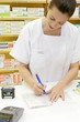 Pharmacienne cochant une ordonnance