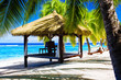 Tropical gazebo with chairs on a beach with palm trees