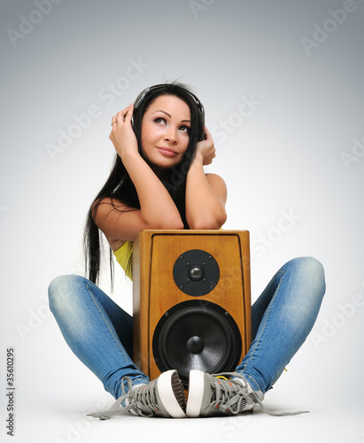 Photo: Young beautiful girl in headphones with speaker Young beautiful girl in headphones with speaker