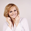 Foto: Smiling young blond haired woman with her hands near her face ho Smiling young blond haired woman with her hands near her face ho