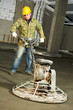 Worker trowelling and finishing of concrete Worker trowelling and finishing of concrete