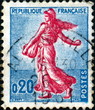Timbre semeuse rouge sur fond bleu.