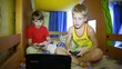 Two boys sit and play a computer game