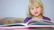 Little girl read a picture-book and something tells