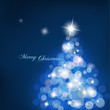 Christmas tree with blurred lights on blue background.
