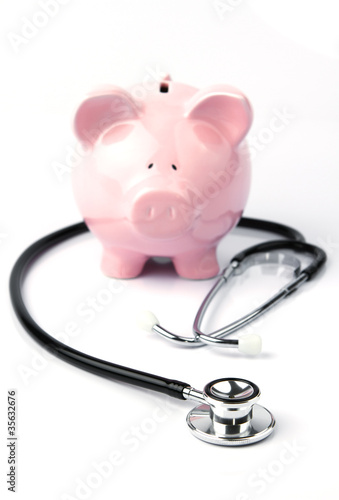 Photo: Piggy bank and stethoscope isolated on white Piggy bank and stethoscope isolated on white