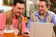 Zwei Freunde in bayerischer Wirtschaft mit Laptop