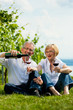 Glückliches Paar trinkt Wein am See im Sommer