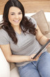 Happy Hispanic Woman Using Tablet Computer At Home
