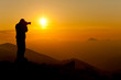 photographer taking picture of landscape during sunset