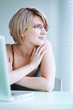 Portrait of a young woman pensively looking out of the window