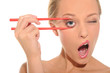 Surprised woman opens her eyes chopsticks
