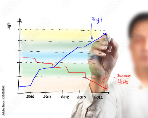 Photo: Business man drawing a graph on a glass window in an office - fo Business man drawing a graph on a glass window in an office - fo