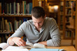Male student researching with a book