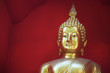 Goldener Buddha vor rotem Hintergrund