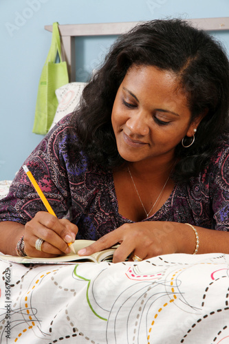 Photo: Woman On Bed Writing Woman On Bed Writing