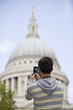 A man taking a photograph of St Paul's cathedral