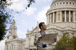 A man standing in front of St Paul's cathedral, looking at a map