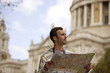A man in front of St Paul's cathedral, looking at a map