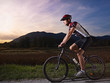 Photo: young man training on mountain bike at sunset young man training on mountain bike at sunset