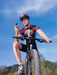 Photo: young man with telephone riding mountain bike young man with telephone riding mountain bike