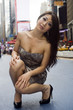 Fashion Model Kneels on Crowded City Street