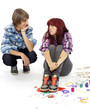 Young boy sits next to a girl covered with paints