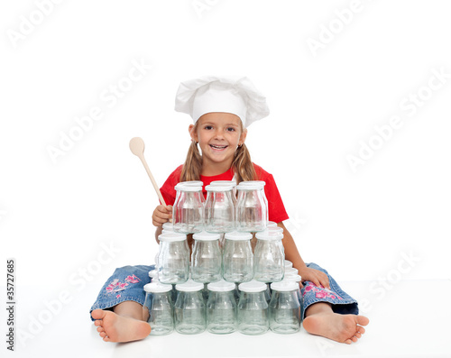 Photo: Happy chef girl with jars for canning Happy chef girl with jars for canning