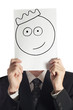 Man with the painted crown smile on the paper over his face
