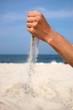 Sand falling from the man's hand