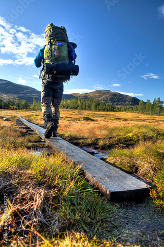 Foto: Wanderer mit Rucksack auf dem Weg durch Moorlandschaft Wanderer mit Rucksack auf dem Weg durch Moorlandschaft