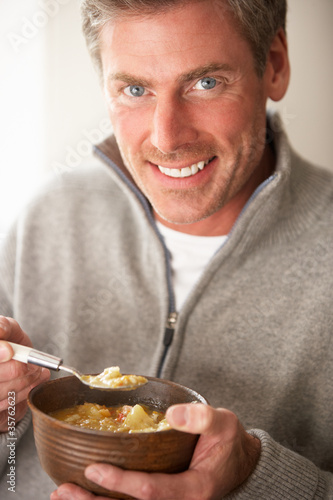 Photo: Man eating bowl of soup Man eating bowl of soup