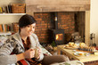 Young woman having tea by fire