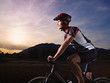 young man training on mountain bike at sunset