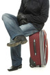 Businessman sitting on a suitcase.