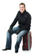 Businessman sitting on a suitcase.
